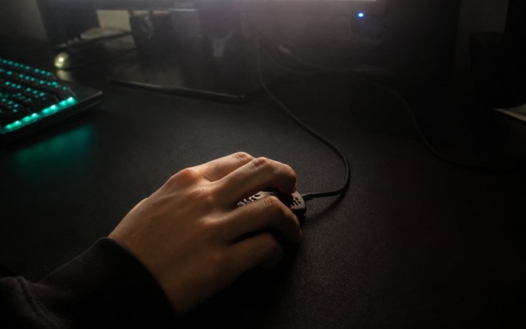 Hand an der Gaming-Maus während einer Runde