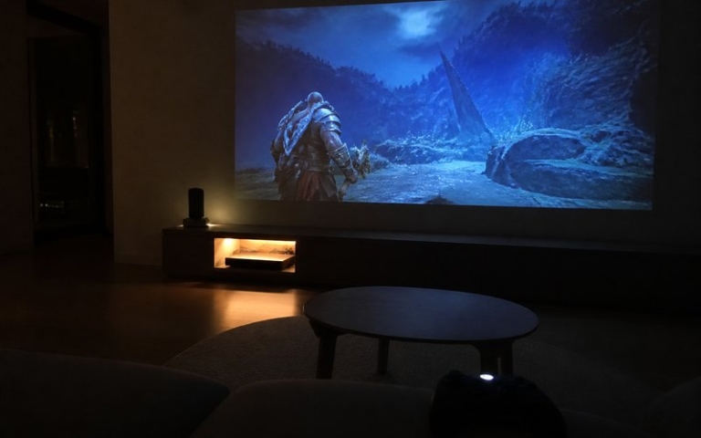 Beamer projiziert Spielbild an die Wohnzimmerwand